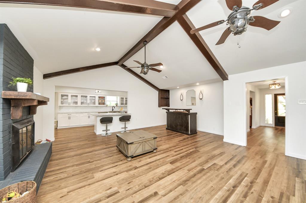 Extra-large living area with a cozy brick fireplace, bar nook, and plenty of space to relax or entertain with ease.