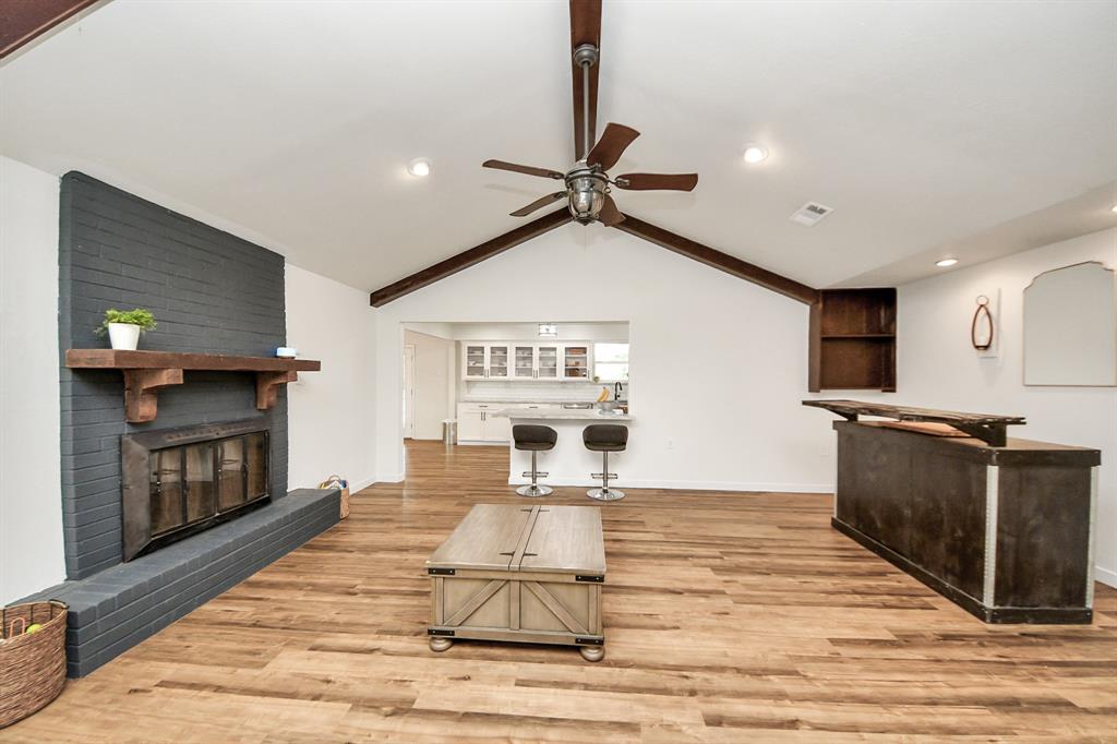 Vaulted ceilings with beams add character to this open-concept living space, seamlessly connected to the kitchen for easy entertaining.