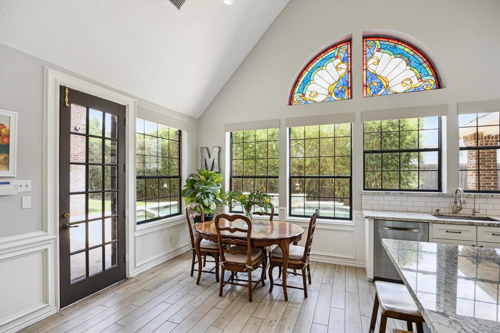 Remodeled kitchen with gas cooktop conversion, granite counters, custom cabinetry, recent dishwasher, and remote-controlled blinds. Vaulted ceilings and stained-glass accent windows fill the space with light, and windows offer a beautiful view of the pool."  Remodeled kitchen with gas cooktop conversion, granite counters, custom cabinetry, recent dishwasher, and remote-controlled blinds. Vaulted ceilings and stained-glass accent window fill the space with light, while large windows offer a beaut