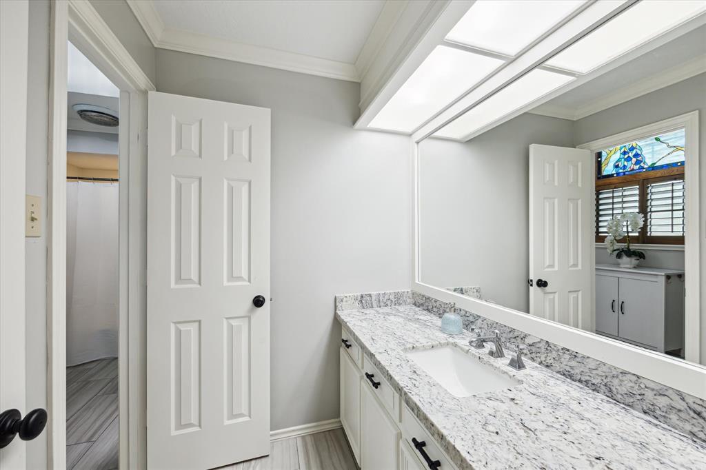 Bright and modern bathroom featuring granite countertops, updated fixtures, and neutral tile flooring. Conveniently located just off the game room or bonus space—ideal for guests or secondary bedrooms.