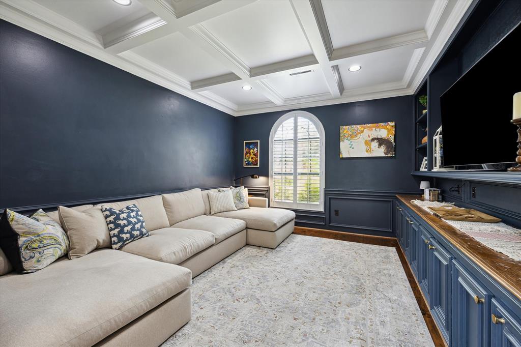 Versatile study with rich navy walls, coffered ceiling, and built-in cabinetry—perfect for a home office, media room, or cozy reading lounge. French doors offer privacy while allowing natural light to fill the space through the arched window with plantation shutters. A beautifully designed flex space to suit your lifestyle.