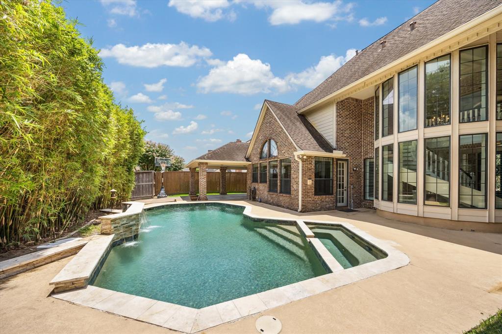 Backyard retreat with a beautifully upgraded saltwater pool featuring a heater, resurfaced pebble finish, water feature, updated tile, and sprayed deck—ideal for relaxing or entertaining year-round.